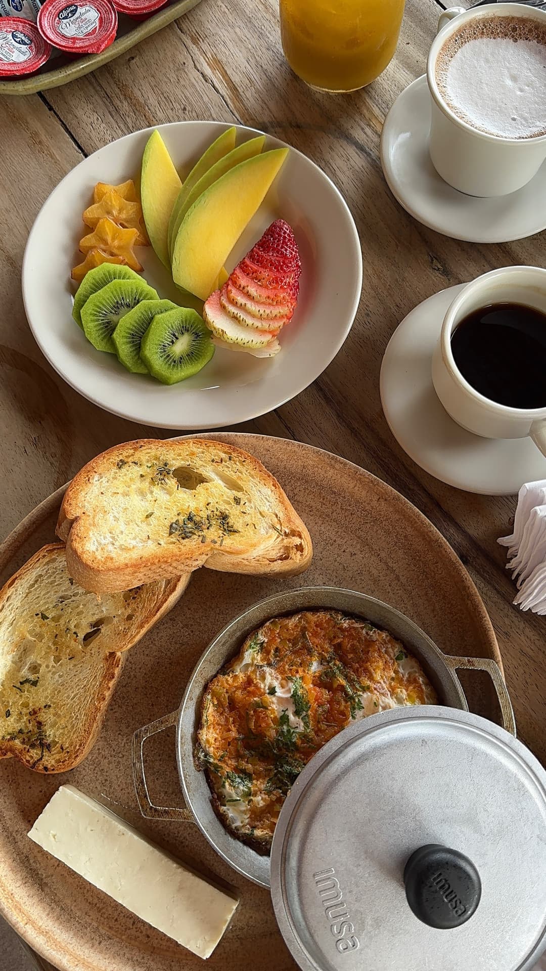 Desayuno con frutas, huevos, pan y café