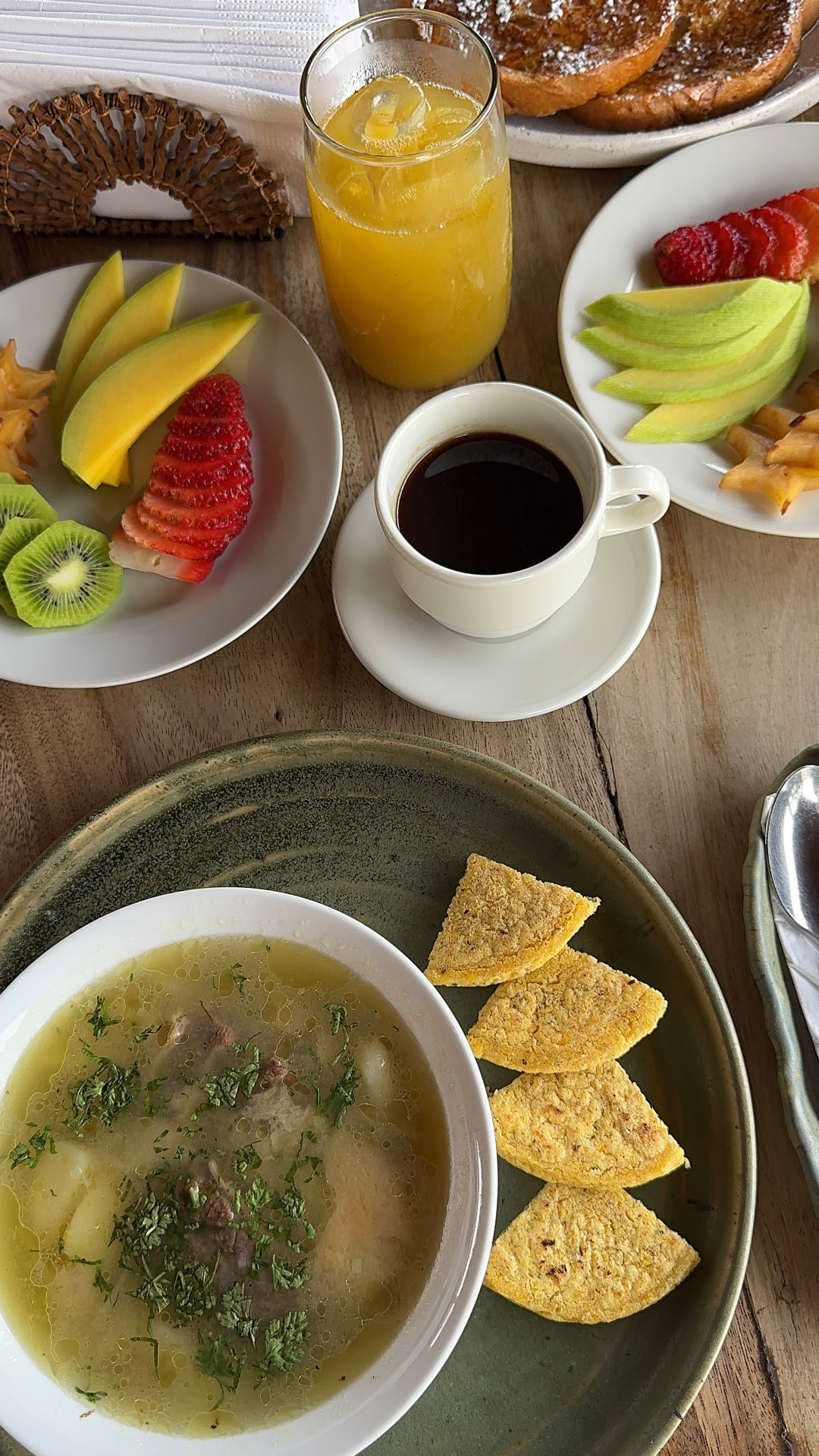 Desayuno con caldo, arepas, frutas y café