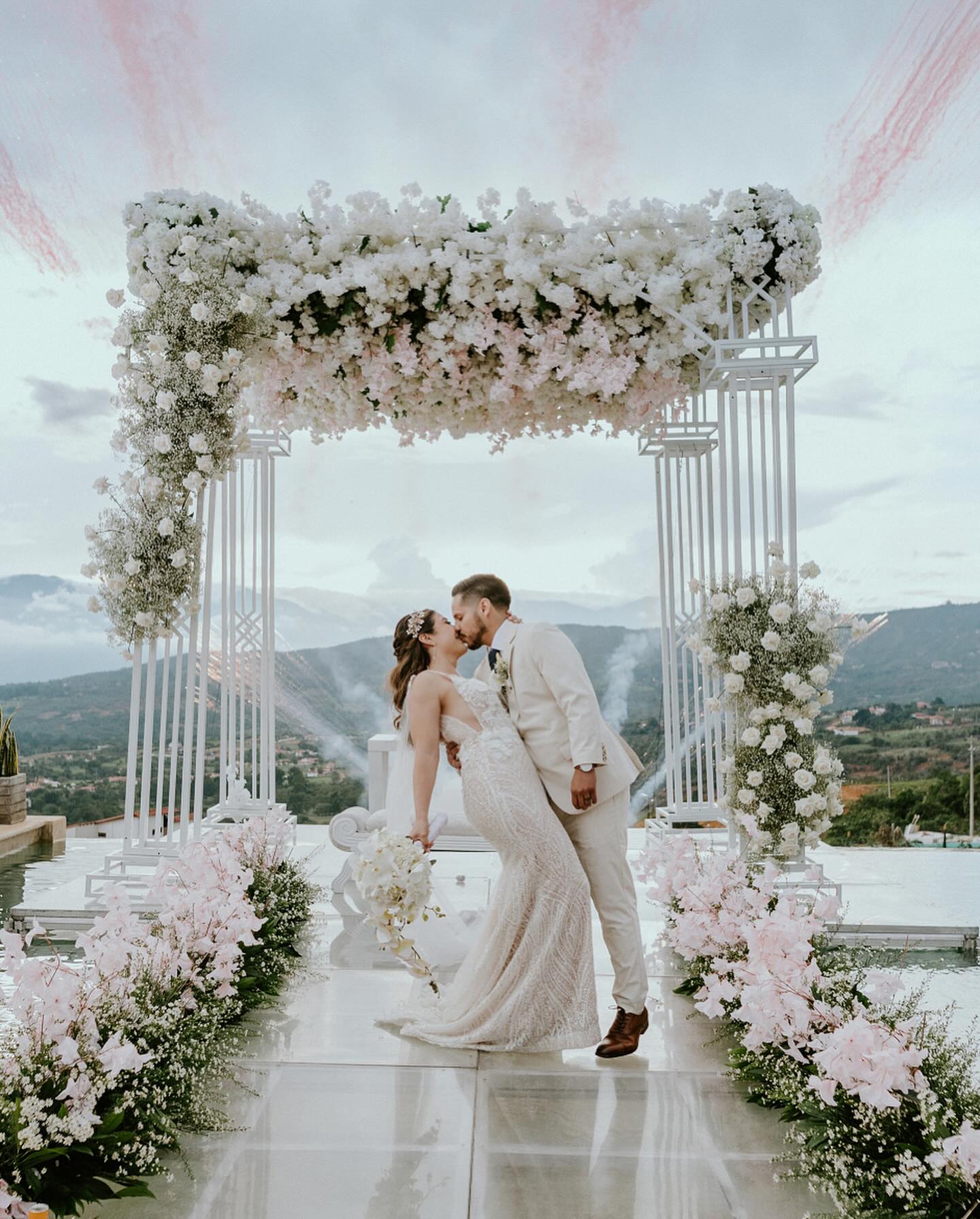 Pareja de novios bajo el arco floral